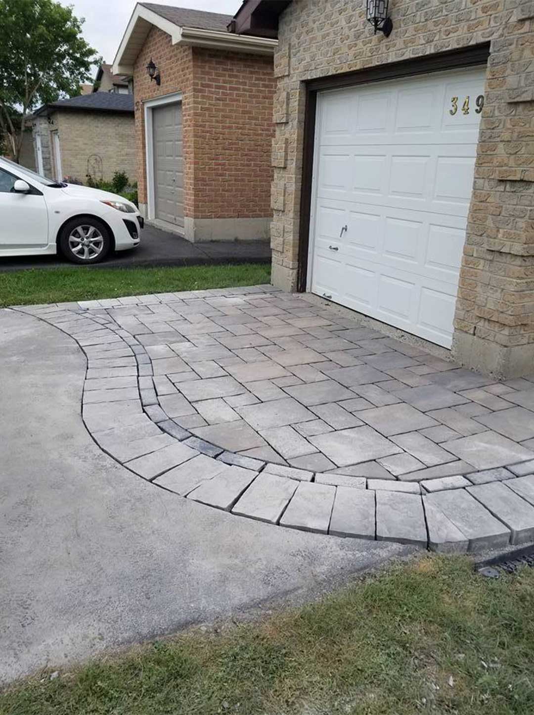 interlocking stone patio at top of driveway in front of garage